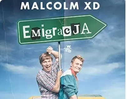 Two smiling men stand in front of a colorful van, holding a large green sign reading "Emigracja." The sky is bright blue with scattered clouds.